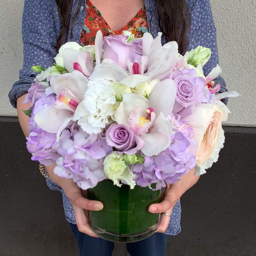 Soft lavenders, whites, and hints of cream. Hydrangea, roses, orchids, with hints of garden lisianthus 