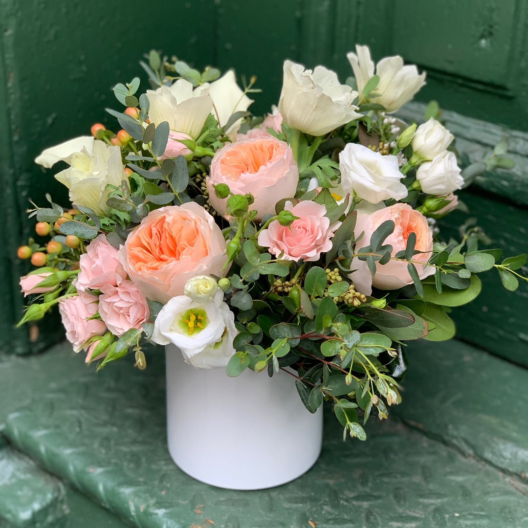 blend of peach garden roses, blush spray roses, white anemone , peach hypericum berry, and mixed eucalyptus