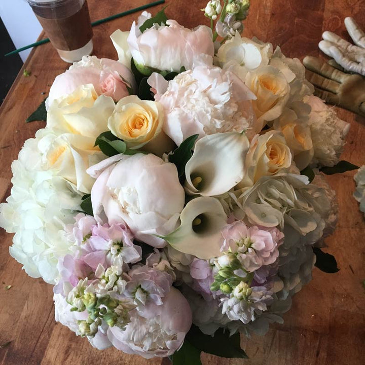 A blend of pastels in blush, light yellow, creams, and whites. Includes a variety of Roses, Peony, Stock, Hydrangea, and Calla.