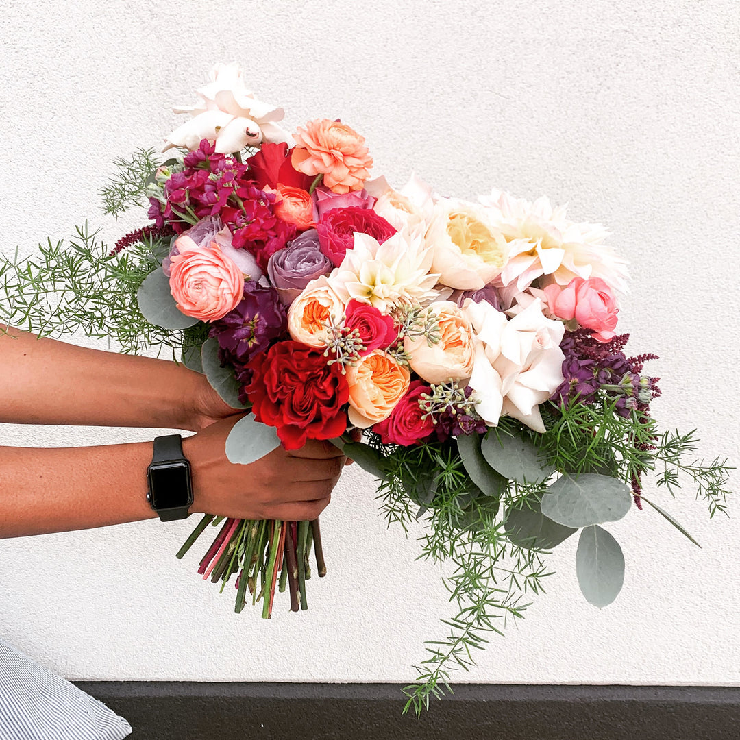 bouquet filled with garden roses, ranunculus, fragrant stock, seasonal dahlia or garden rose substitute, and delicate greenery