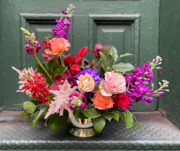 A mix of purple, red, pink, peach, and orange flowers.