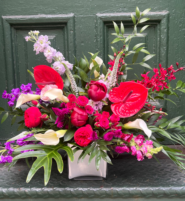 Bright and Bold flowers designed with a garden style flair. Bright Reds, Pinks, and pops of white and purple.