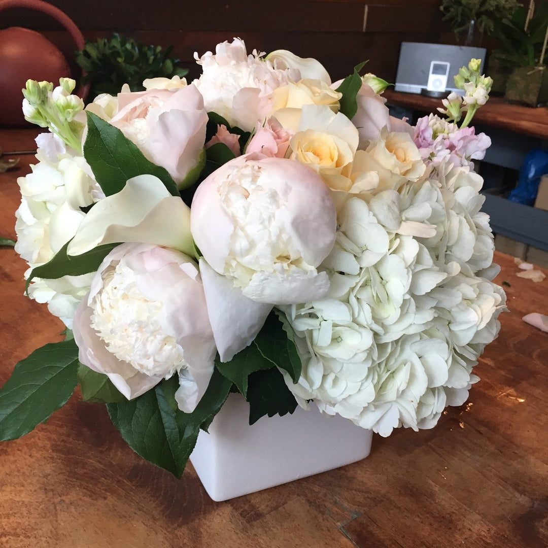A blend of pastels in blush, light yellow, creams, and whites. Includes a variety of Roses, Peony, Stock, Hydrangea, and Calla.