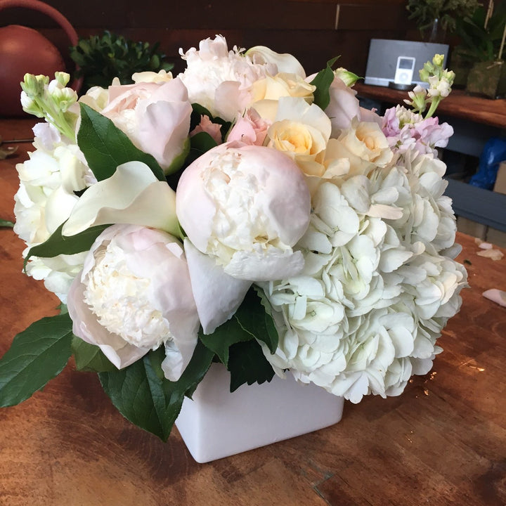 A blend of pastels in blush, light yellow, creams, and whites. Includes a variety of Roses, Peony, Stock, Hydrangea, and Calla.