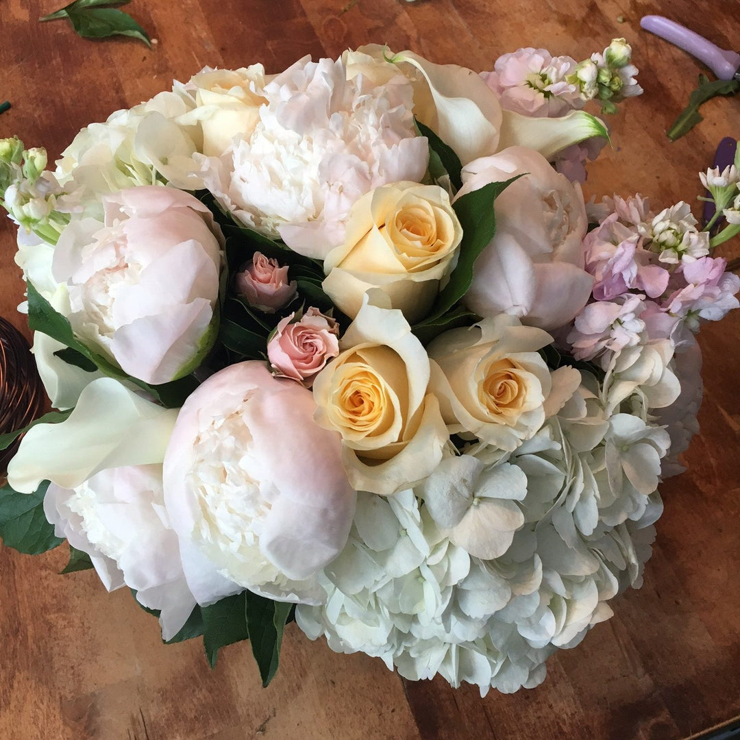 A blend of pastels in blush, light yellow, creams, and whites. Includes a variety of Roses, Peony, Stock, Hydrangea, and Calla.