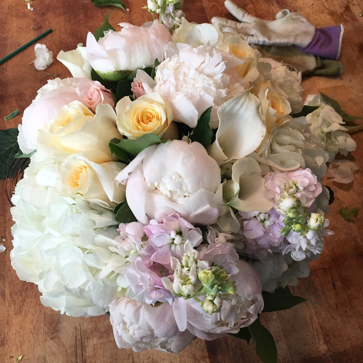 A blend of pastels in blush, light yellow, creams, and whites. Includes a variety of Roses, Peony, Stock, Hydrangea, and Calla.