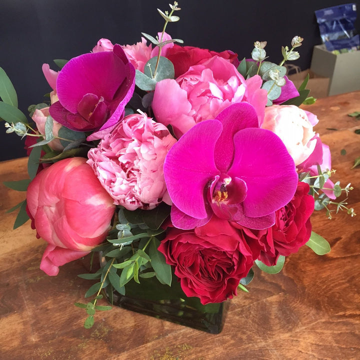 Fuchsia Orchids, Mix Of Pink and White Roses, Pink Peony, and Eucalyptus accents.