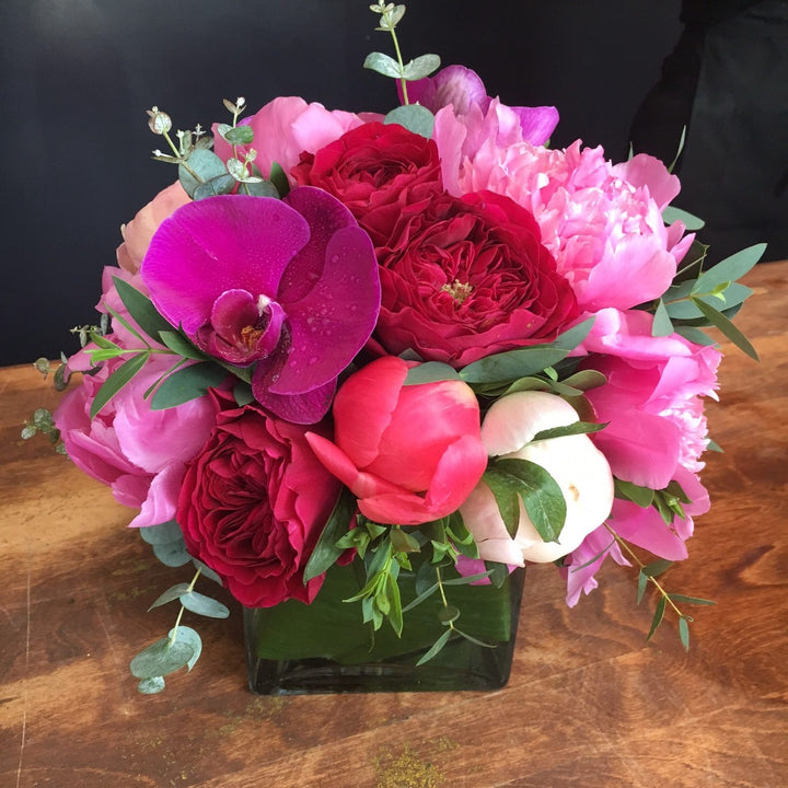 Fuchsia Orchids, Mix Of Pink and White Roses, Pink Peony, and Eucalyptus accents.