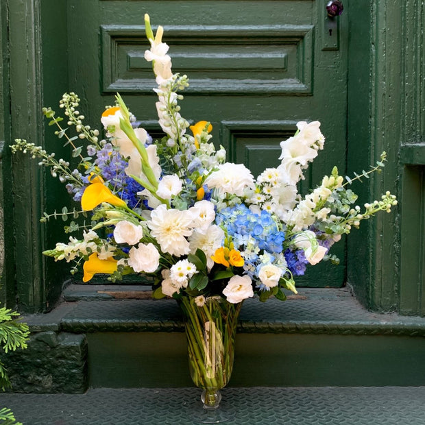 Tall White flowers -- delphinium with a mix of gladiolus, Yellow Calla, Hints of Blue, White Rose. Tall stately Vase