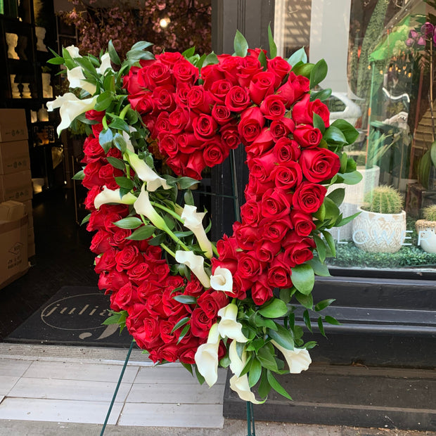 Luxurious Red Roses designed in an Open Heart with White Calla Lillies.