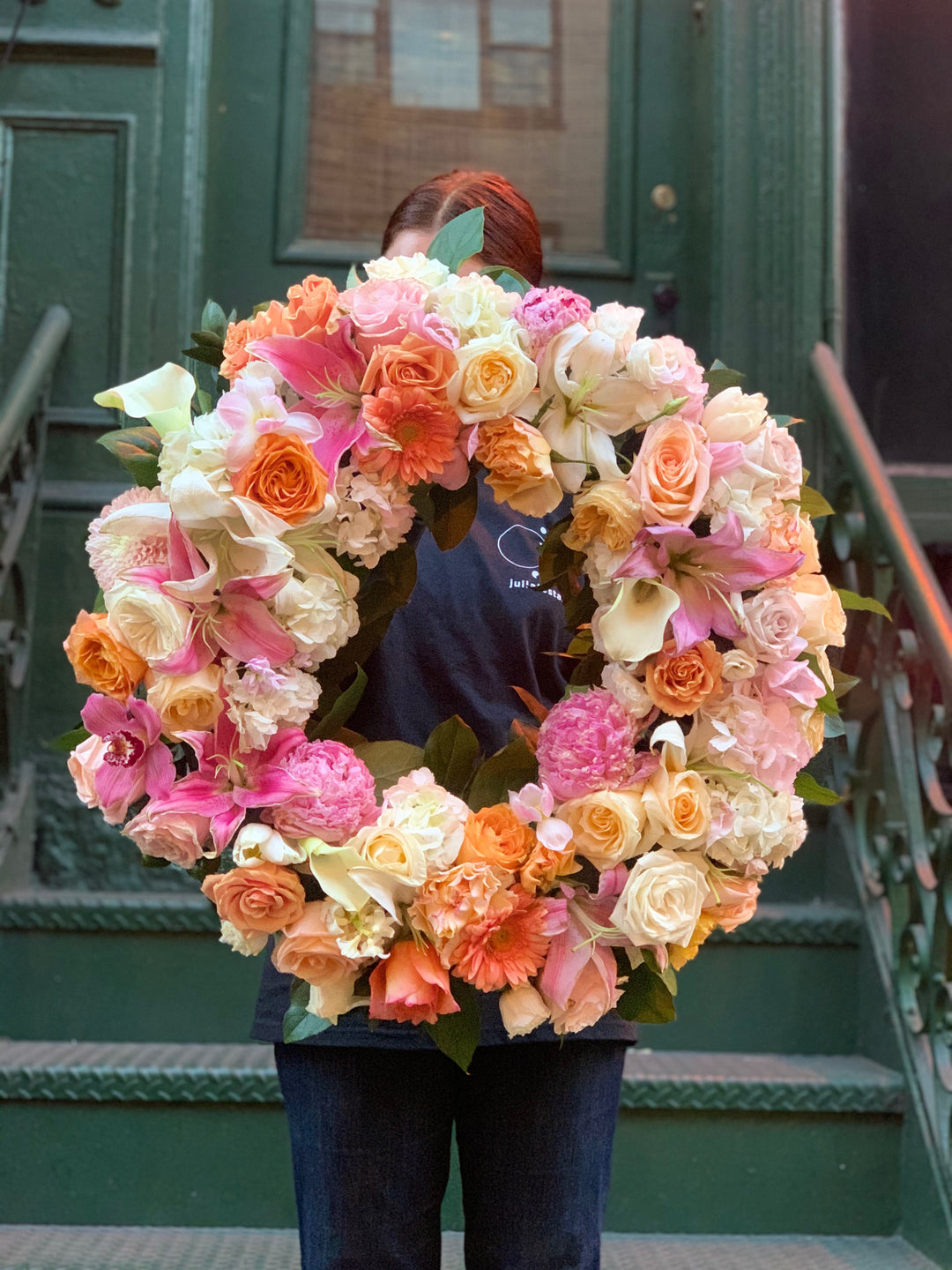  Funeral wreath of peach, white, pinks, orange blooms, and Hints of yellow.
