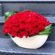 Dozens of Roses designed tightly in an oval container 