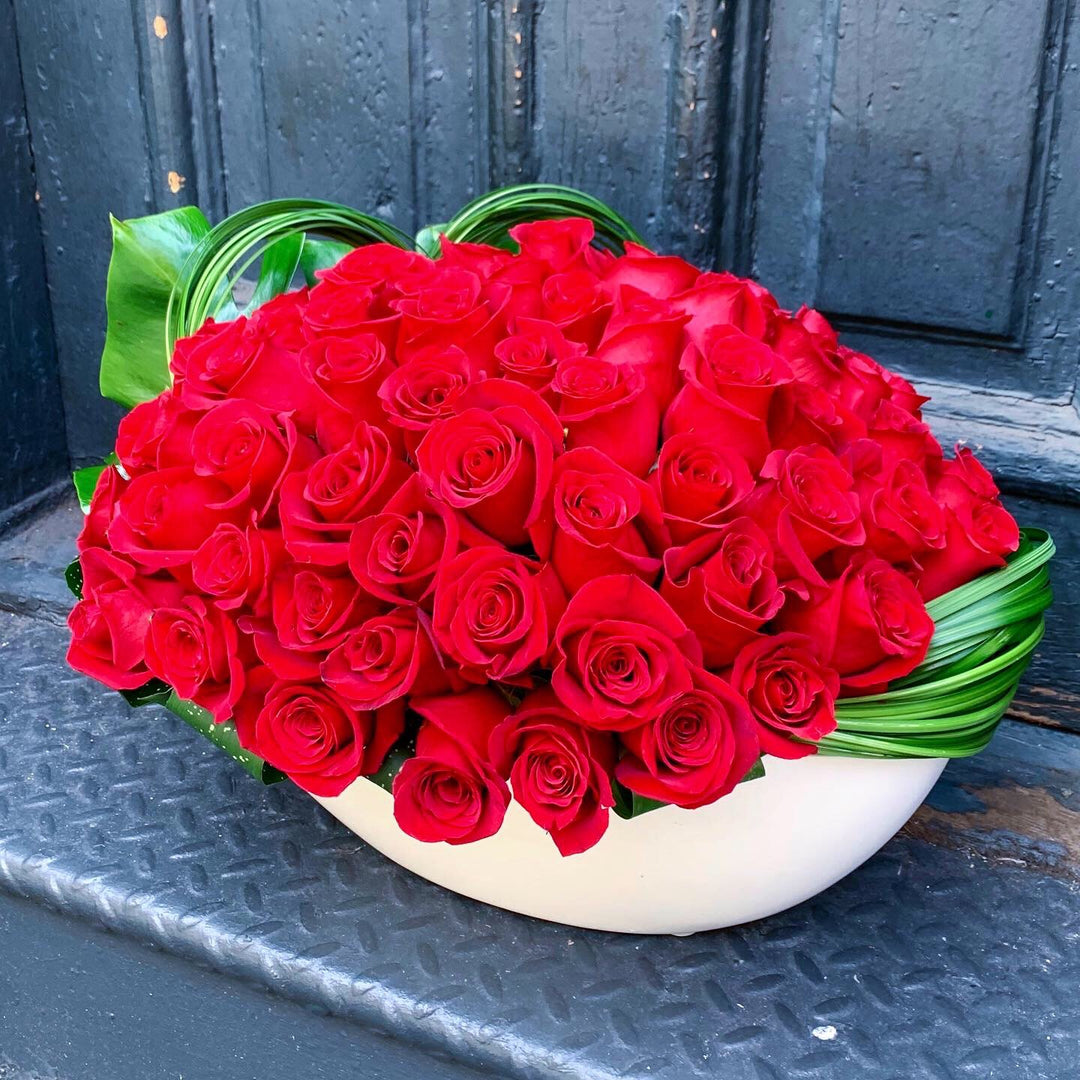 Dozens of Roses designed tightly in an oval container 