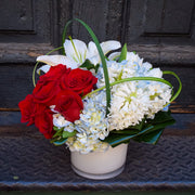 red roses, blue hydrangea, and white hyacinth, lilies, and tulips