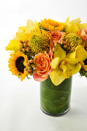  sunflowers, yellow orchids, protea, and tropicals with accents of berries