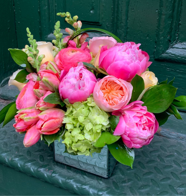 Lush peony, ranunculus, garden roses, parrot tulips, hydrangea, and hints of snap dragon or stock flower.