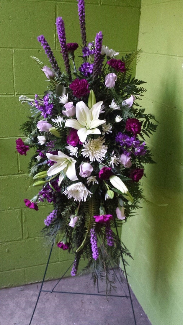 standing spray fragrant lilies, stock, carnations, roses, liatris, and beautiful tones of purple, lavender, and white